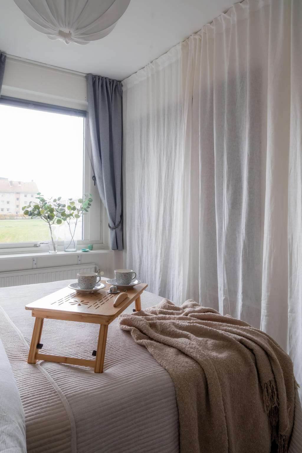 Bakom draperiet döljer sig en garderob.