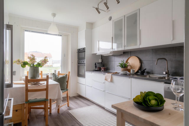 Nyare kök med vit köksinredning och integrerade vitvaror