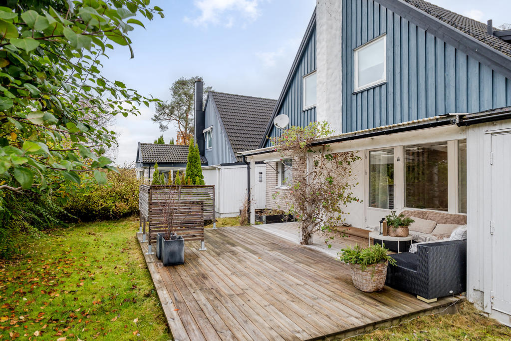 Insysnskydda baksida med stor altan som delvis är under tak.