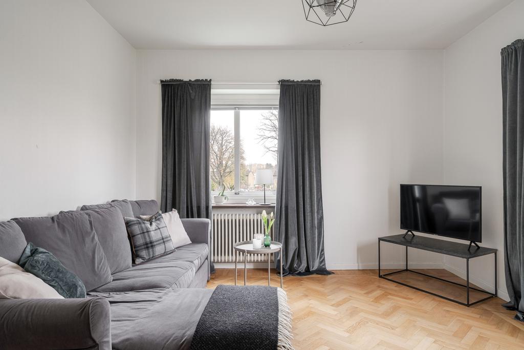 Ljust vardagsrum med fönster i två väderstreck