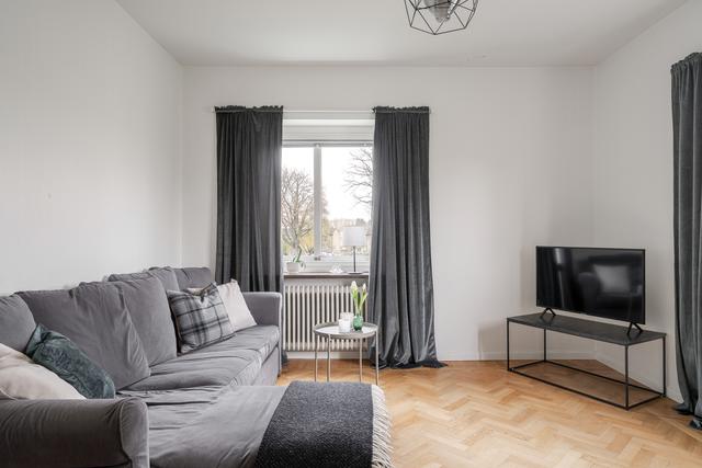 Ljust vardagsrum med fönster i två väderstreck