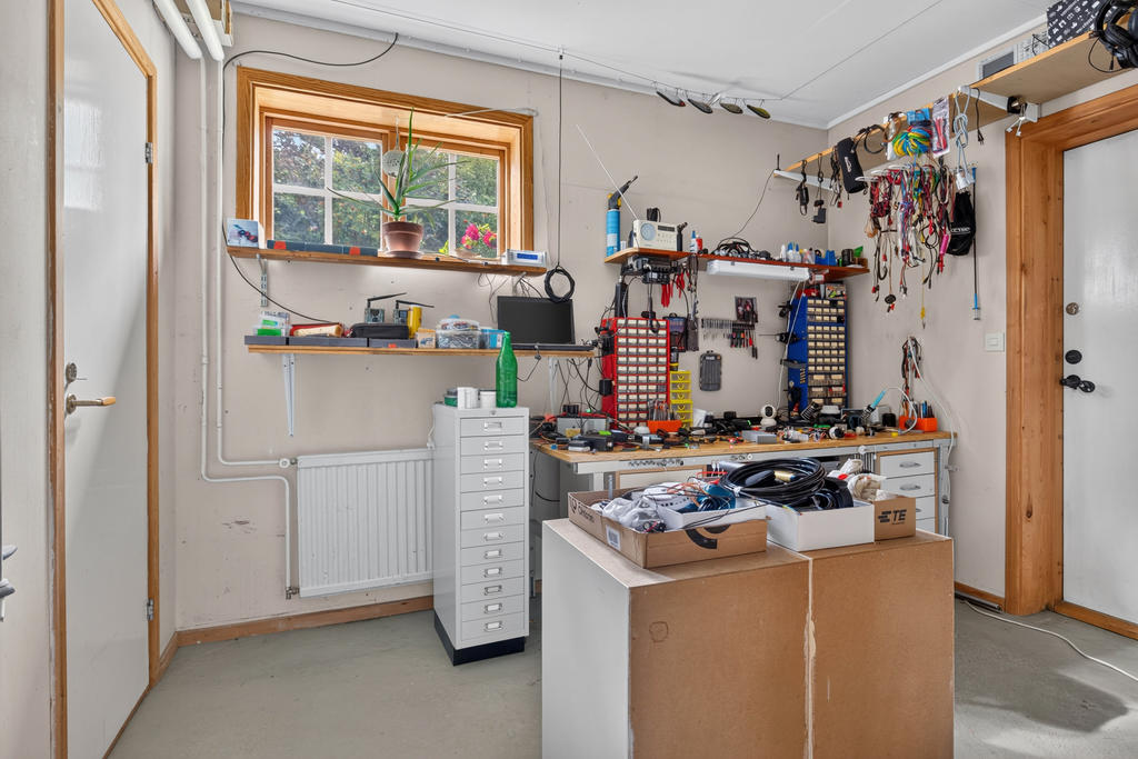 Förrådsutrymme i bakkant av garage. Utgång till tomten. 