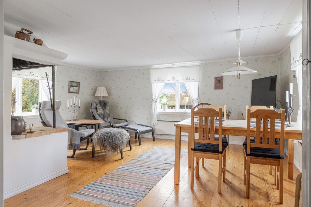 Storstuga med utsikt över de öppna fälten och braskamin.