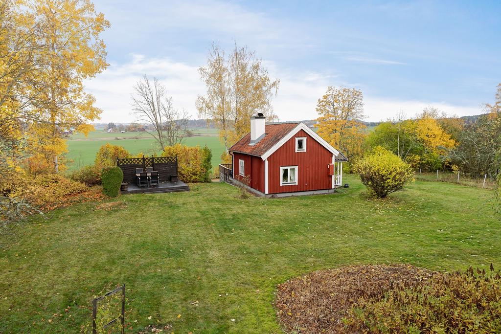 Delvis plan trädgårdstomt med altandäck och kvällsol