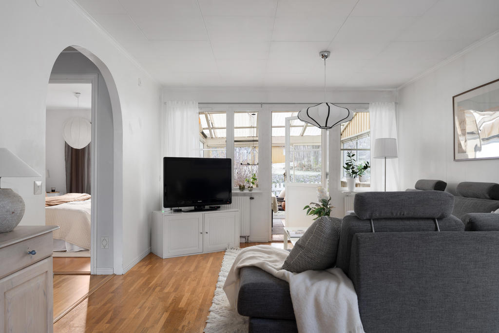 Stort vardagsrum med utgång till den inglasade altanen i rakt söderläge.