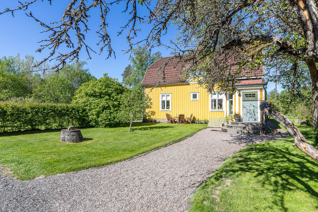 Trivsam baksida med entré som leder vidare in i köket 