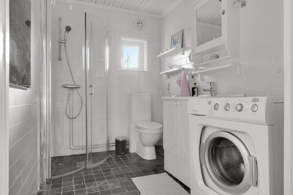 Helkaklat badrum med dusch och tvättmaskin 