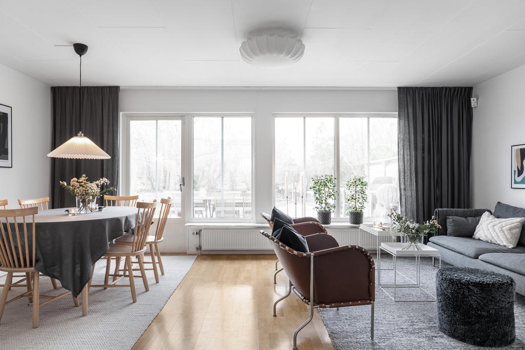 Ljust fint vardagsrum med plats för både soffa och matbord.