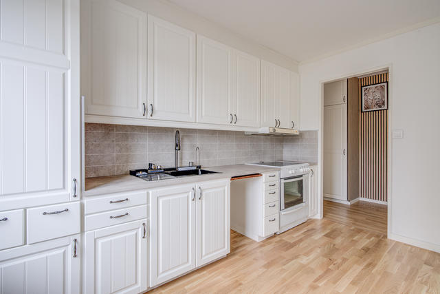 Ljust och fint kök med ny bänkskiva, ny backsplash, ny diskho samt nyare vitmålad skåpinredning och ekparkettgolv. 