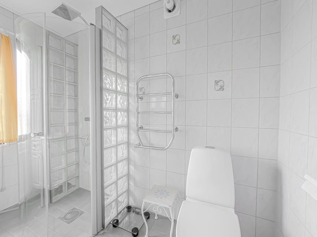 Badrum med tvättställskommod, handdukstork, wc, dusch, klinkergolv och kaklade väggar