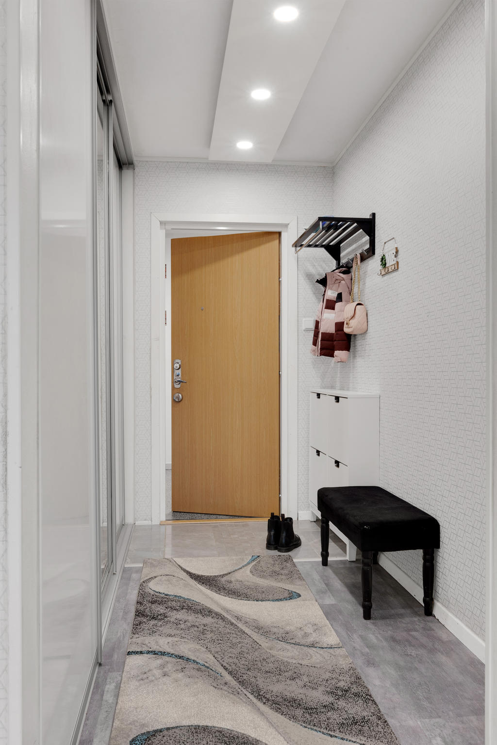 Hall med fin detalj med belysningen och klinker som övergår i vinylgolv 