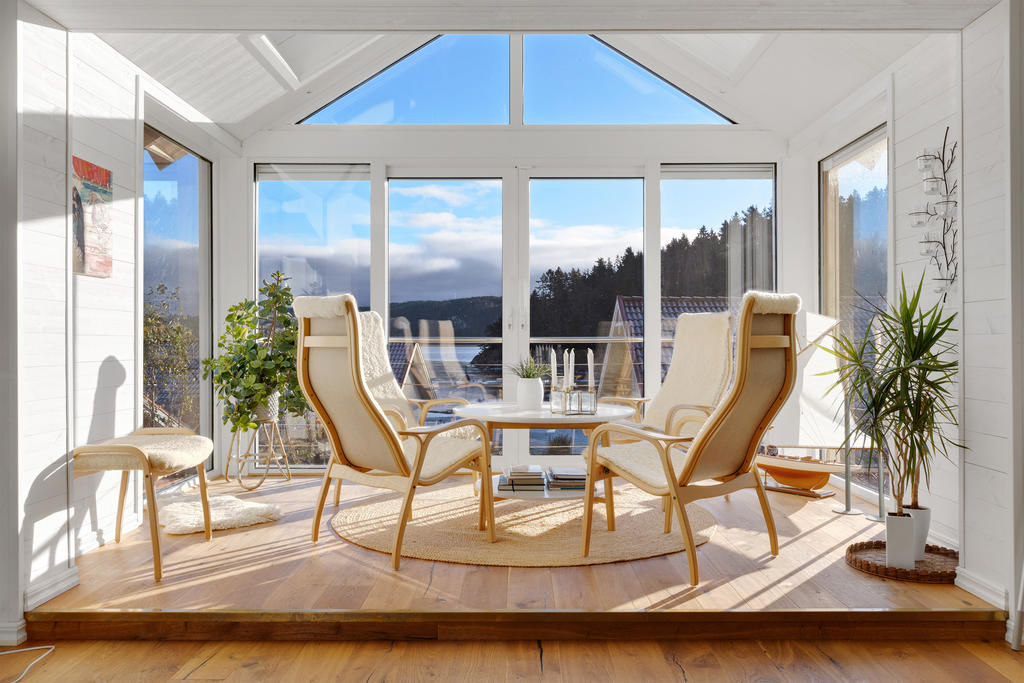 Inbyggd balkong som byggts om till en härlig sällskapsyta med ett vackert ryggåstak och stora fönster som går att öppna och som skapar ett ljust och luftigt intryck
