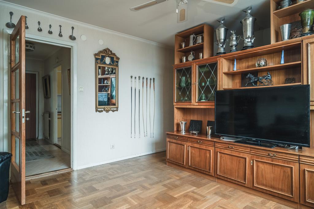 Vardagsrum med möjlig sovalkov bakom hyllan