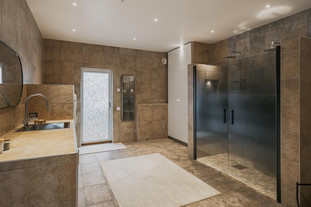 Det nyrenoverade badrummet bjuder på exklusiv känsla med kaklade väggar, stora ytor, dubbla duschar och genomtänkta detaljer.