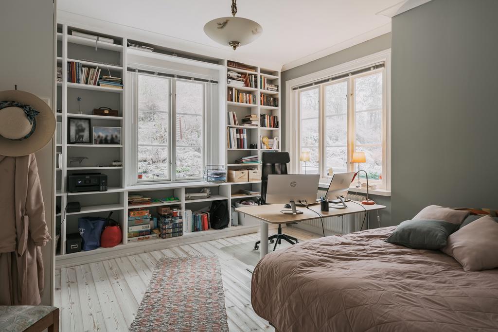 Det här rummet på nedervåningen erbjuder både sovrum och kontorsmöjlighet, komplett med praktisk platsbyggd bokhylla.