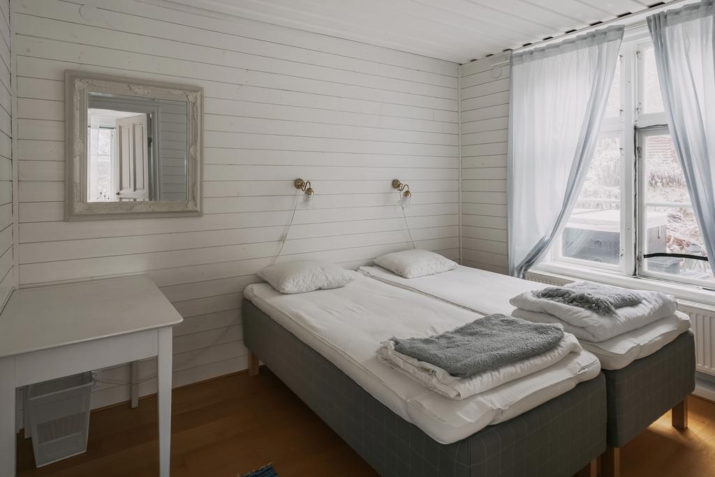 Direkt från salongen når du ett av hemmet mysiga sovrum.