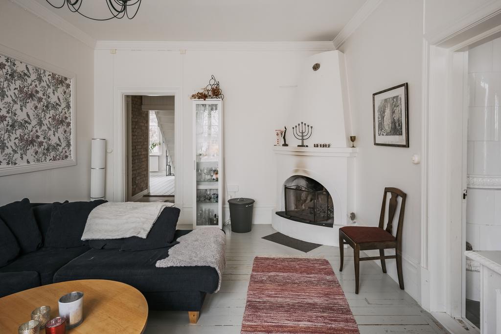 Vardagsrummet ligger bekvämt i anslutning till hallen och här sprakar ännu en öppen eldstad.