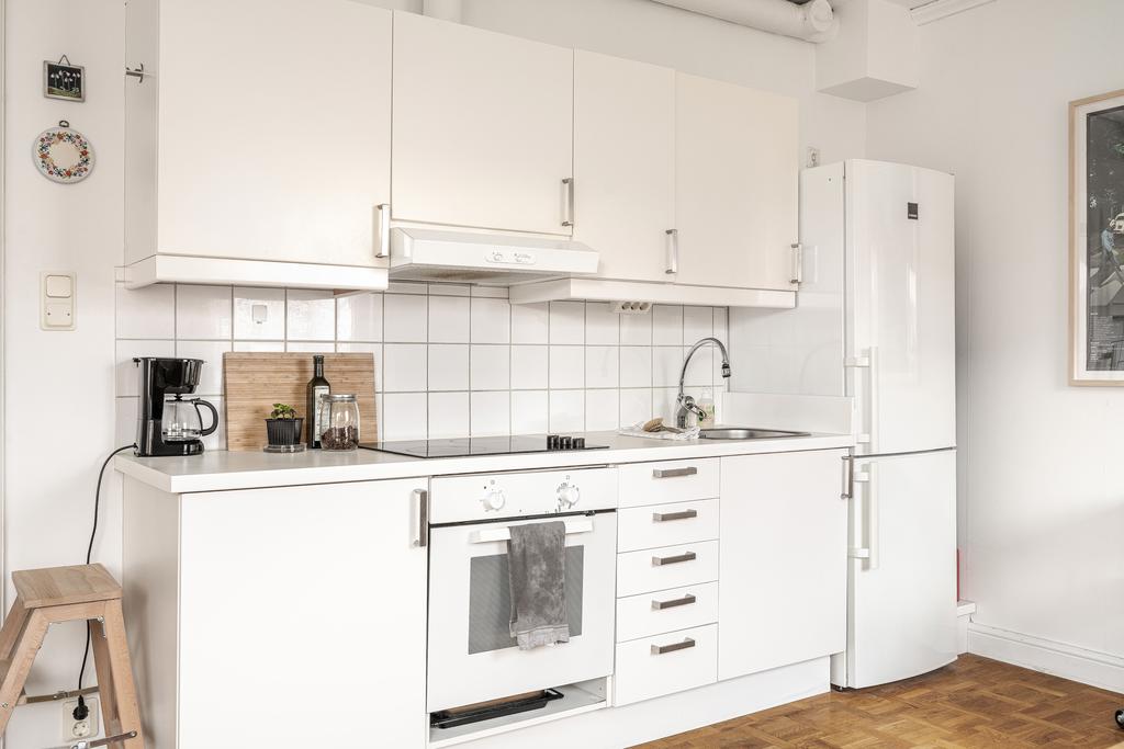 Kök i vitt med kaklat stänkskydd