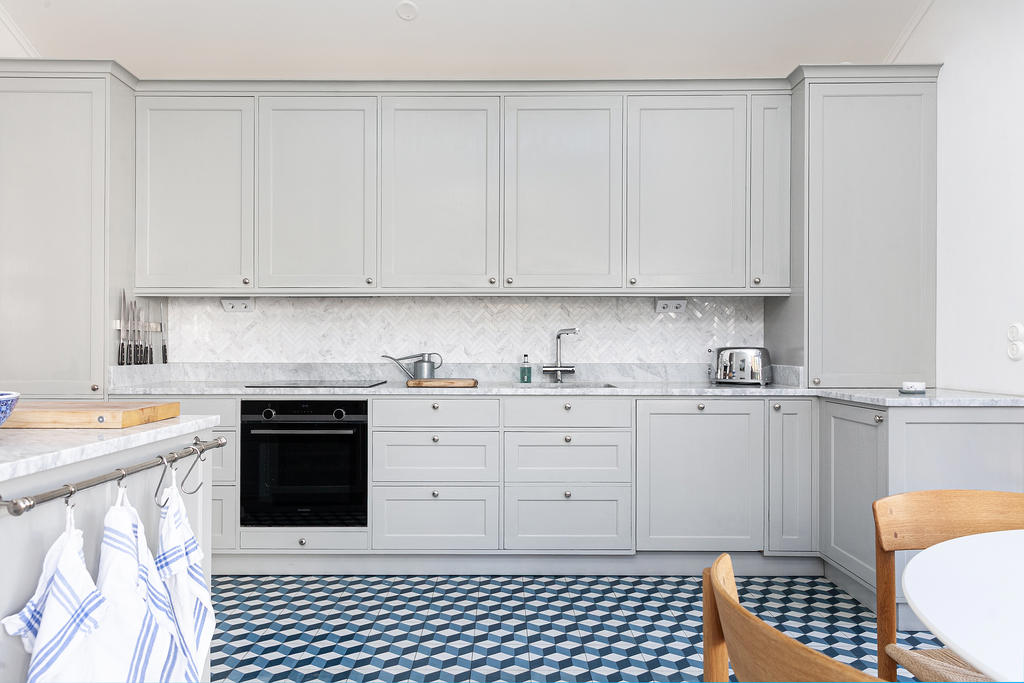 Läckert golv och stilrena luckor som döljer gott om förvaring. Inbyggd kyl/frys