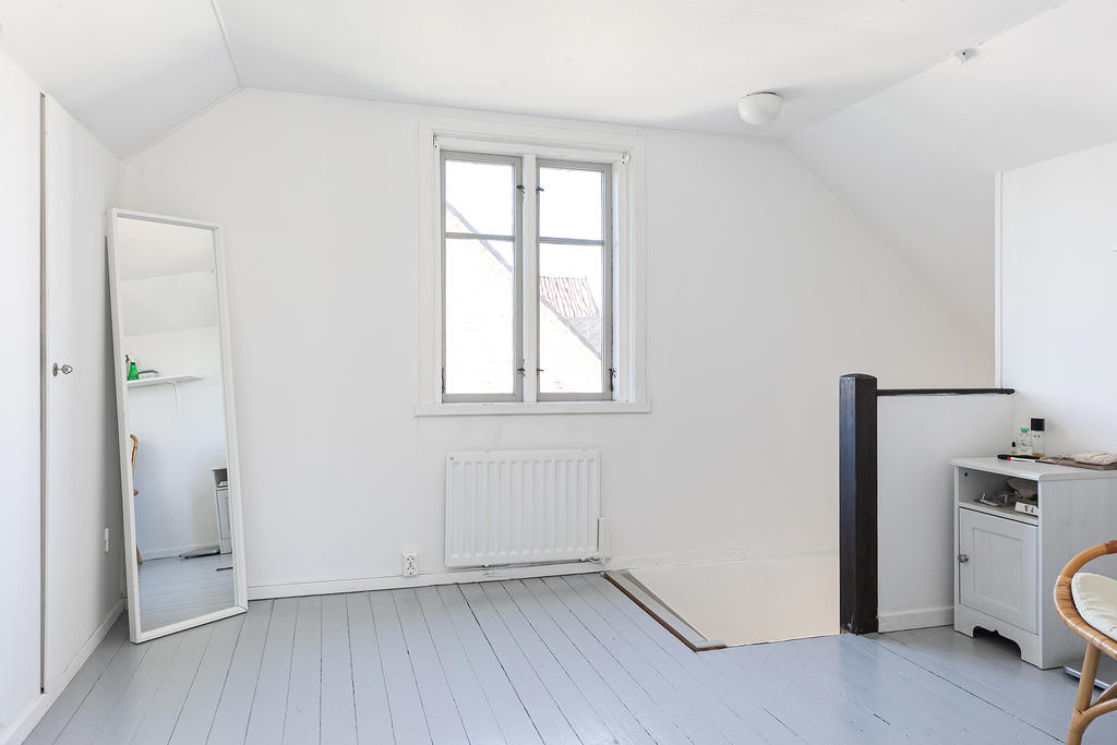 Ovan trappan väntar ett allrum med garderober som sträcker sig in i kattvinden