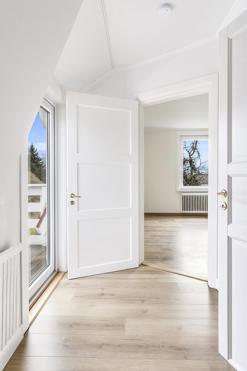 Övre hall med utgång till balkong via helglasad dörr