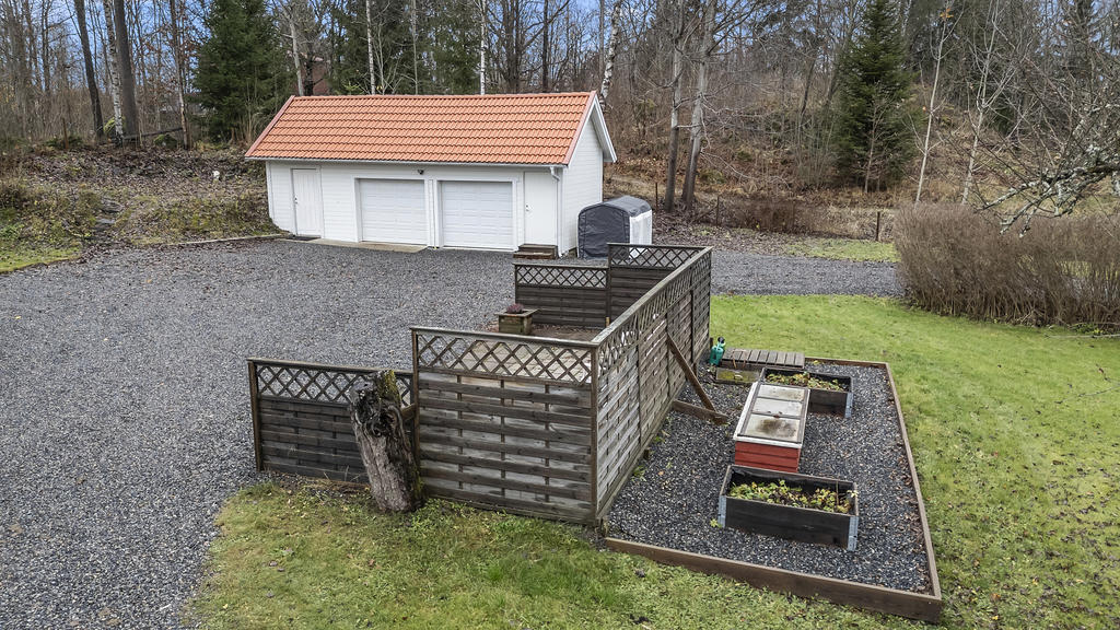 Dubbelgarage och uteplats intill odlingslådor