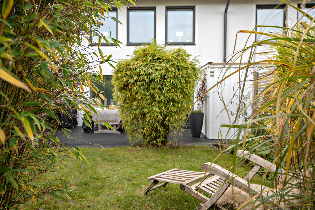 Trädgården är omsorgsfullt planerad med en gräsmatta, altan och en trevlig rabatt