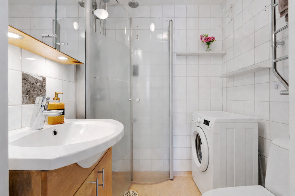 Badrum med dusch och tvättmaskin