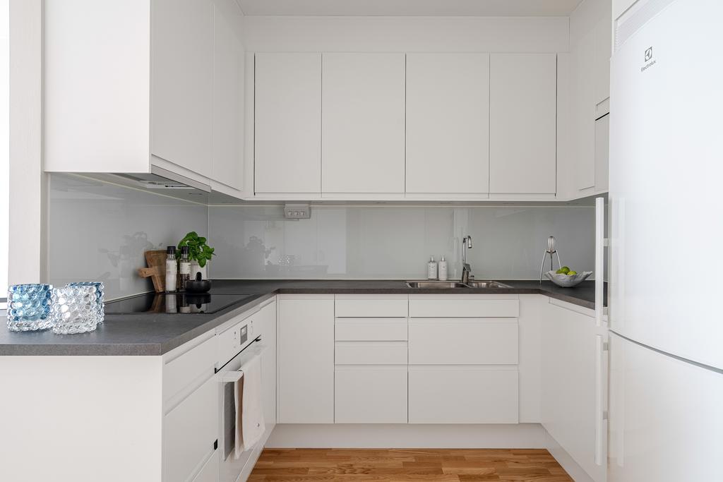 Kök i vitt med släta luckor och bänkskiva i laminat