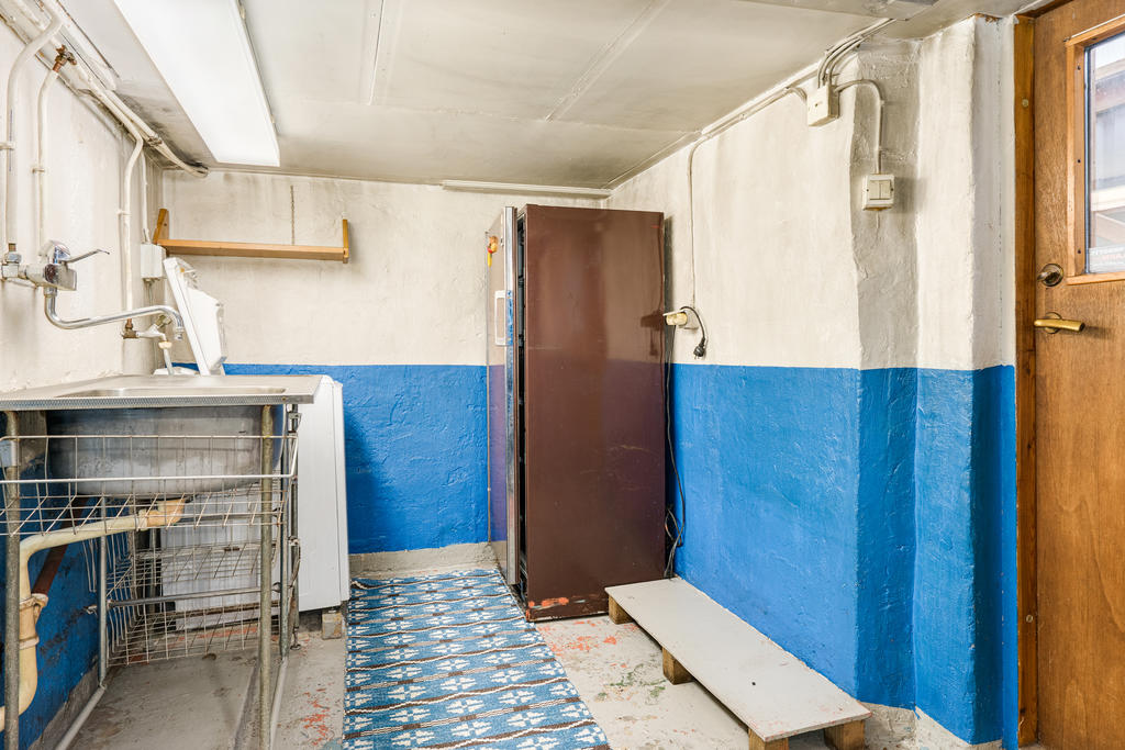 Tvättstuga på källarplan med tvättmaskin. Inkommande vatten. Ingång utifrån. 