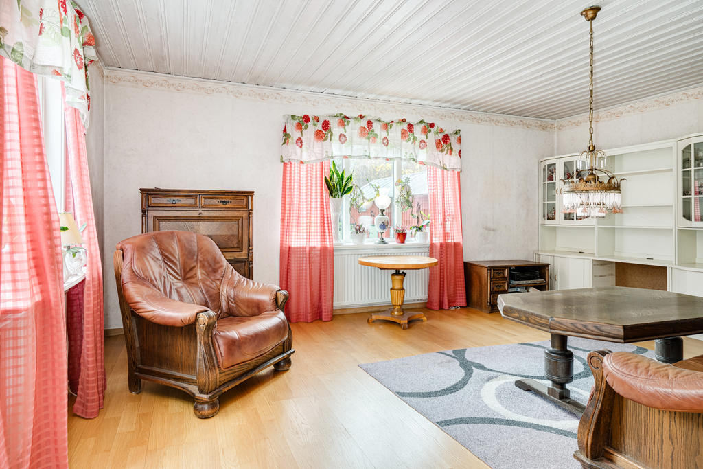 Hemtrevligt vardagsrum med stora fönster som ger mycket ljusinsläpp.