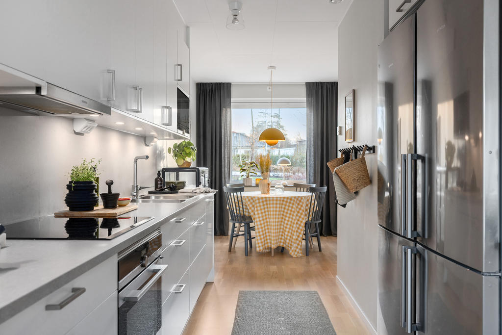 Stilrent kök med rostfria vitvaror och en praktisk dubbel kyl och frys
