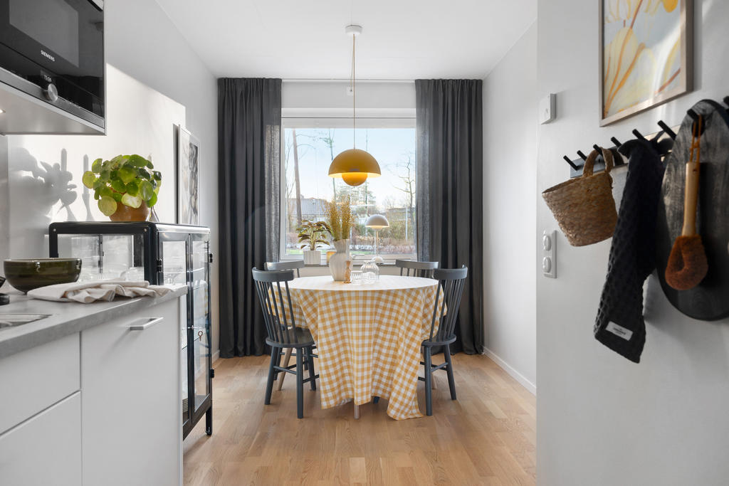 Matplats vid fönstret med utsikt över den lugna återvändsgatan med gräsmatta och lekplats