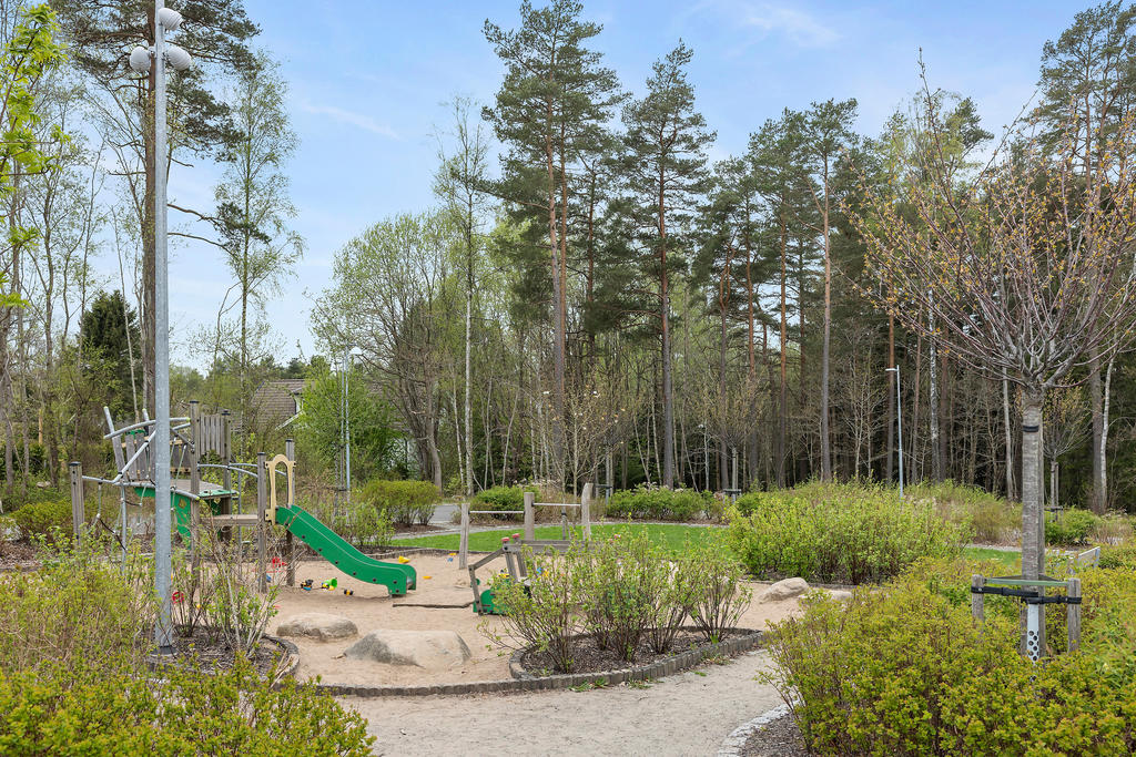 Lekplatsen utanför badar i grönska sommartid