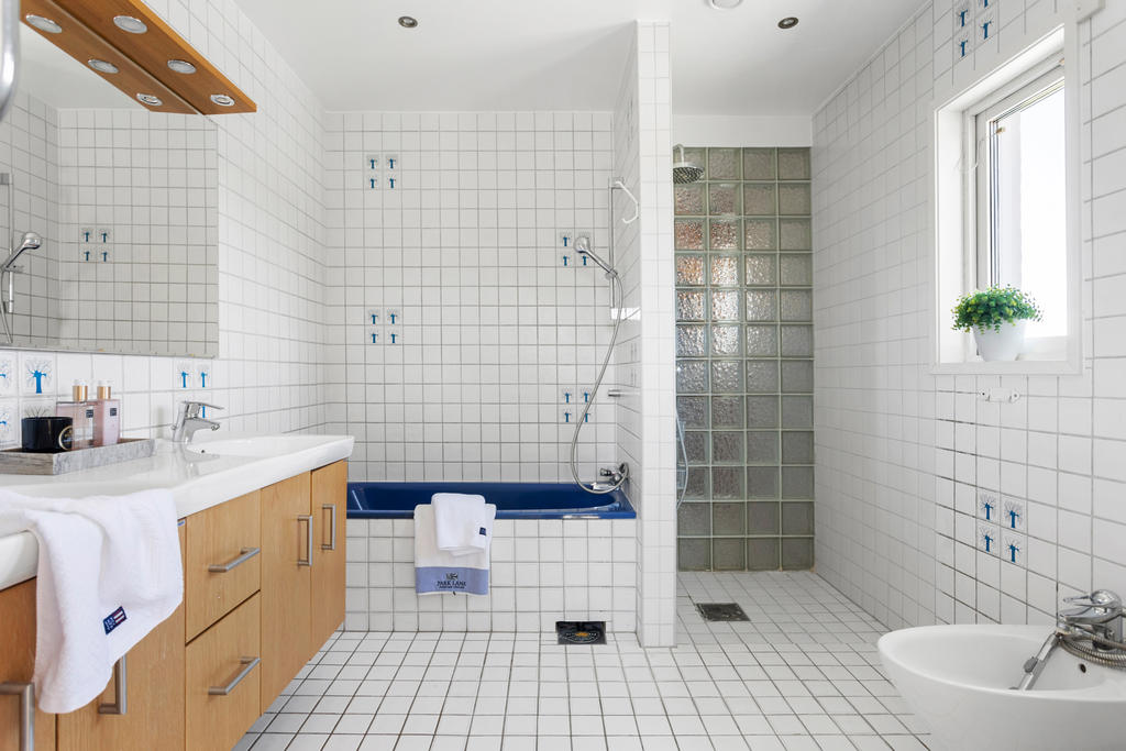On suite - badrummet. som ligger i anslutning till master bedroom. Här erbjuds både badkar och dusch samt en dubbel kommod.
