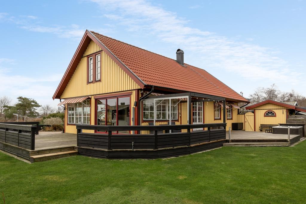 Exteriör baksida med uppvuxen trädgård.