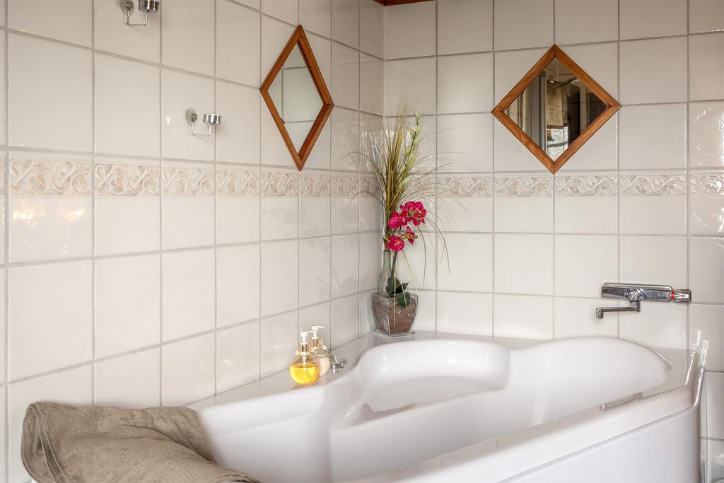 Helkaklat badrum i klassisk stil med badkar och ljusa material.