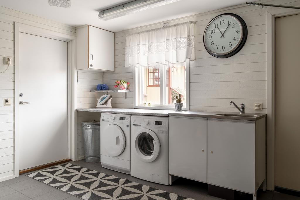 Ljus och funktionell tvättstuga med arbetsyta, förvaring.