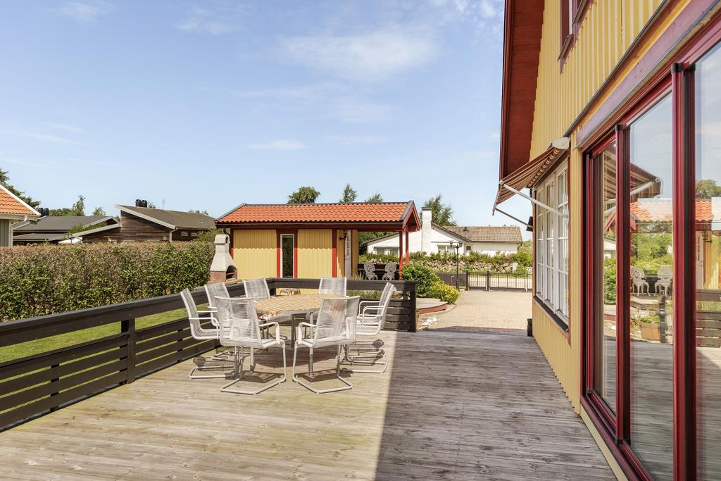 Husets gavel med uteplats och anslutande trädgård.