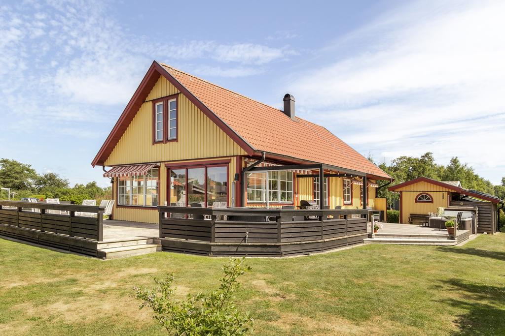 Exteriör baksida med uppvuxen trädgård.