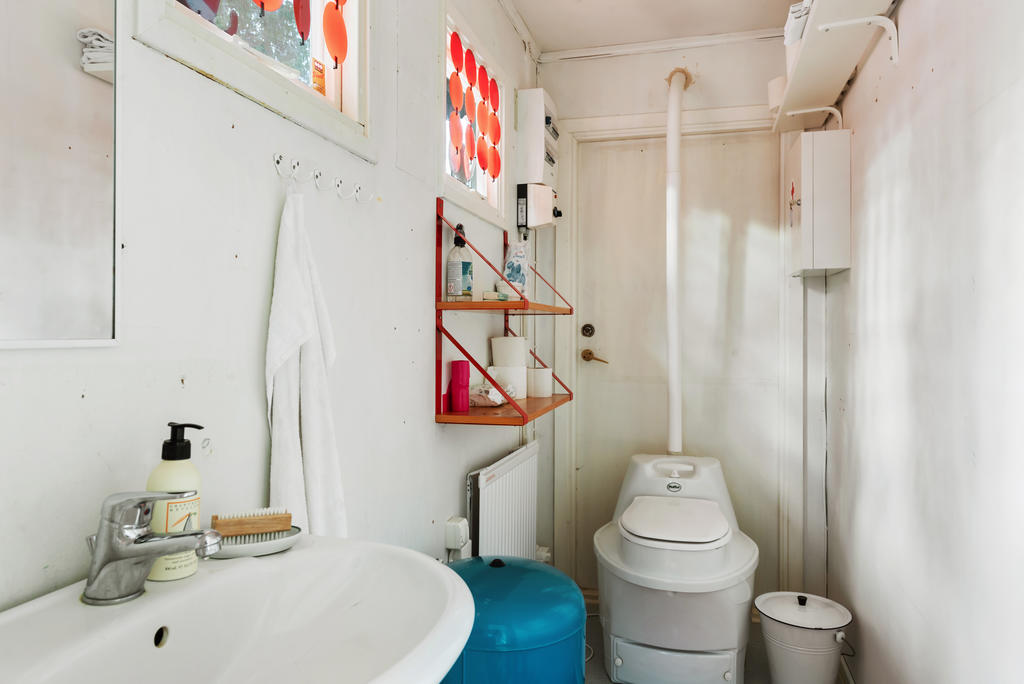 Utrymme med mulltoalett och handfat.