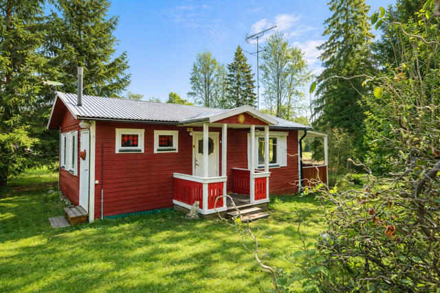 Röd stuga i sommarljus. (Bilden är modifierad till en sommarbild.)