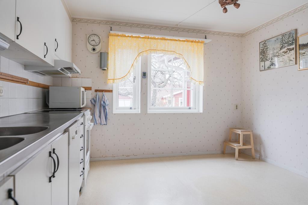 Ett ljust och lättmöblerat kök med plats för både matlagning och förvaring.