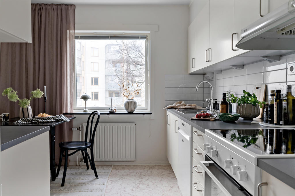 Ljust kök med släta, vita luckor.