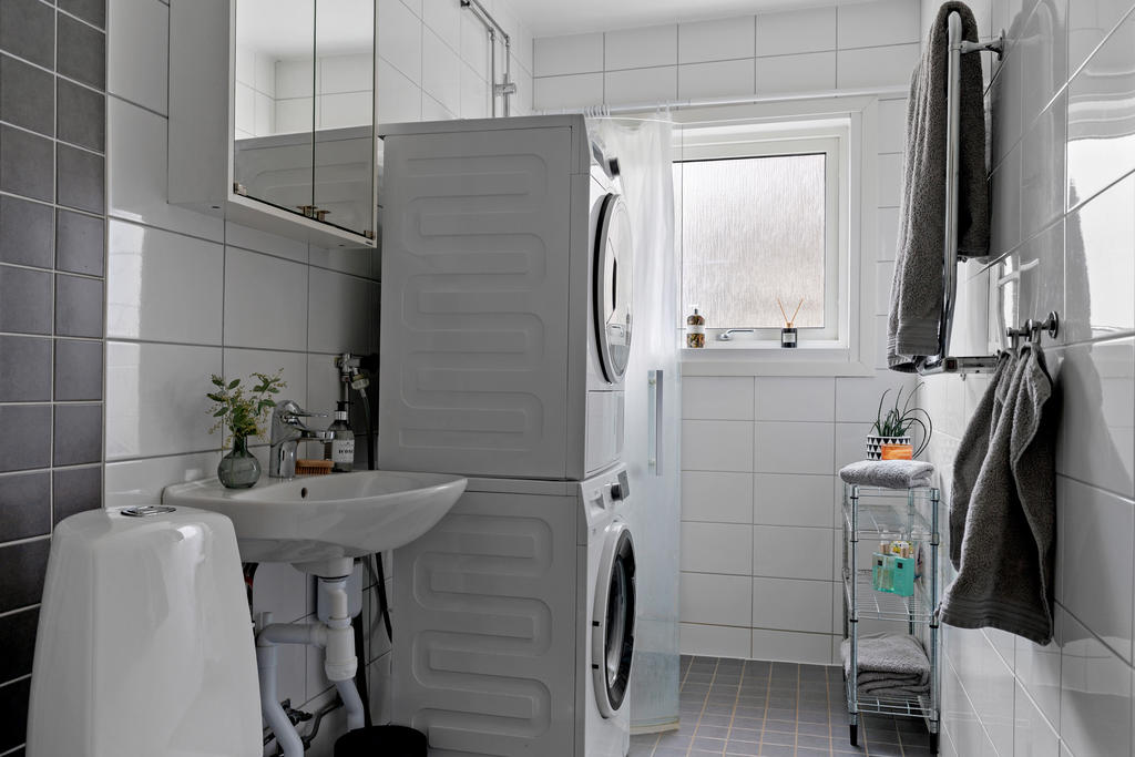 Fräscht, helkaklat badrum med både tvättmaskin och torktumlare.