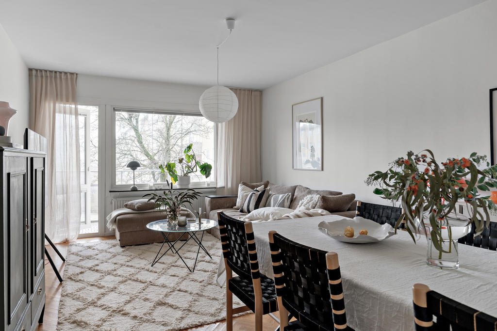 Lättmöblerat vardagsrum med plats för både soffgrupp samt matbord.