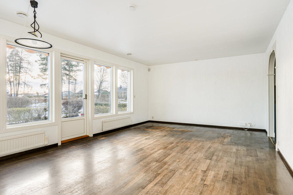 Stort och luftigt vardagsrum med mycket ljusinsläpp och  utgång till uteplats. 