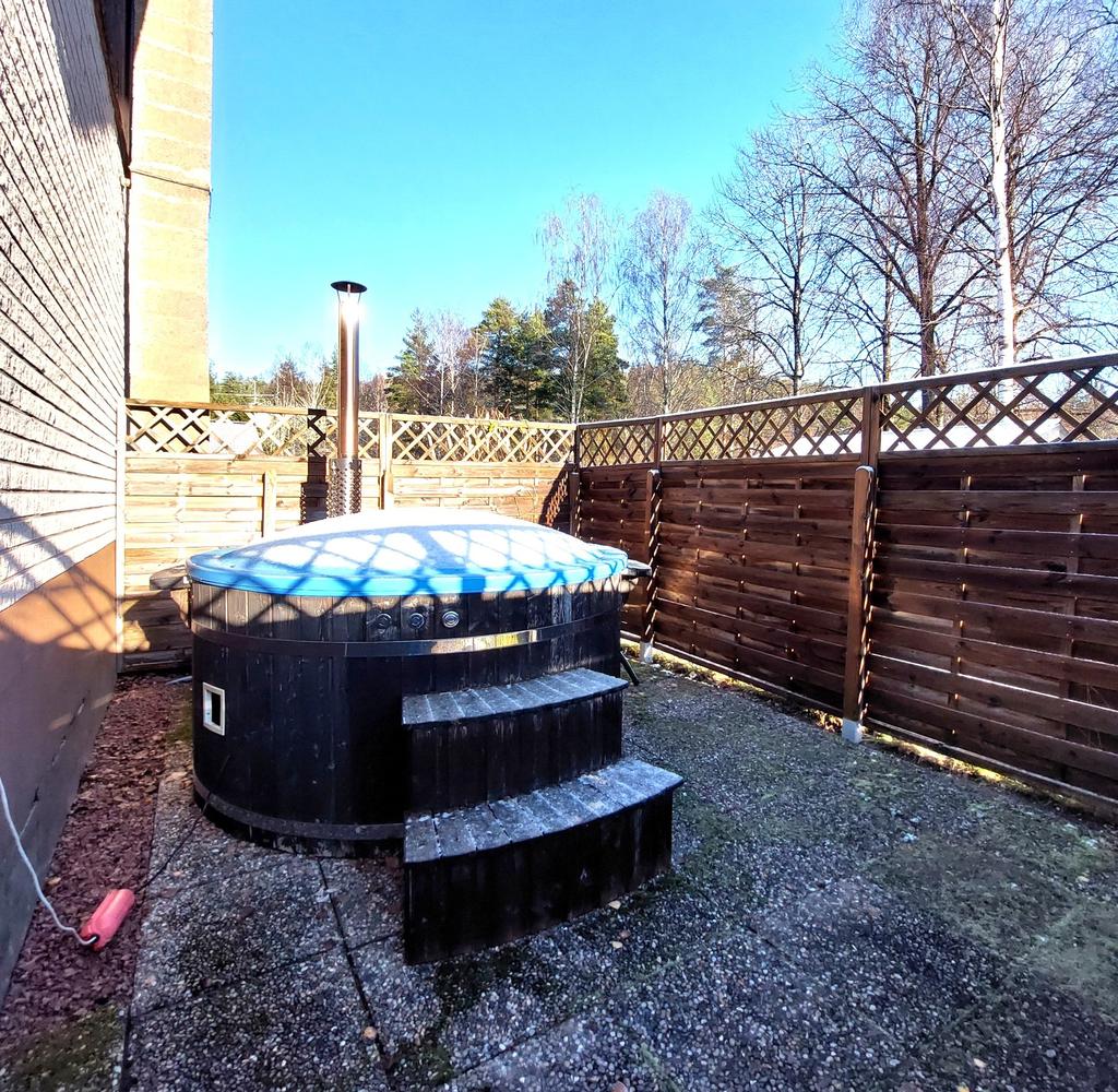 Badtunna på utsidan, inhägnat med spaljé. Med trappa ner in till källaren.