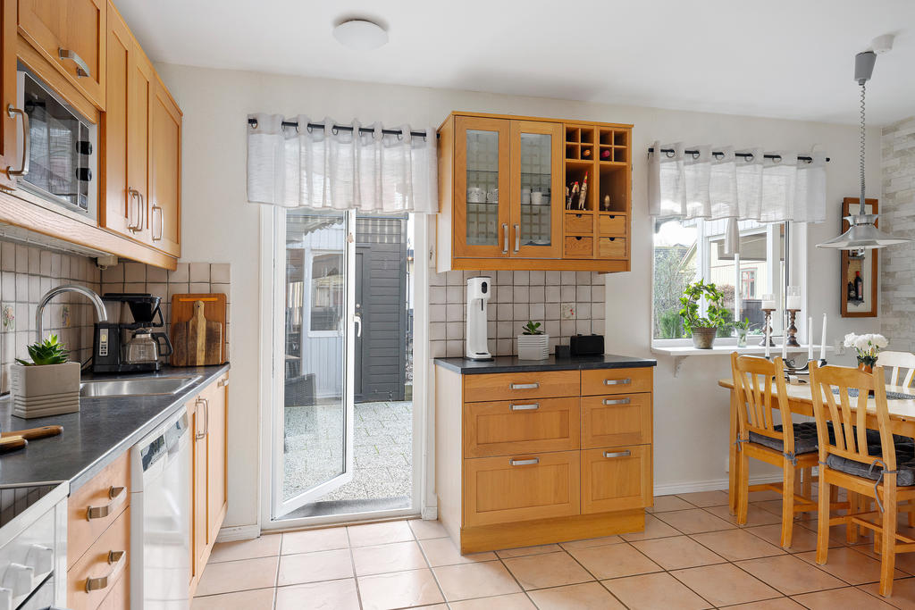 Kök med utgång till den stensatta uteplatsen och trädgården