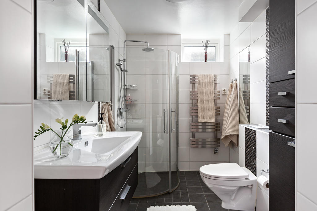 Stilrent helkaklat badrum i sobra färger på entréplan.